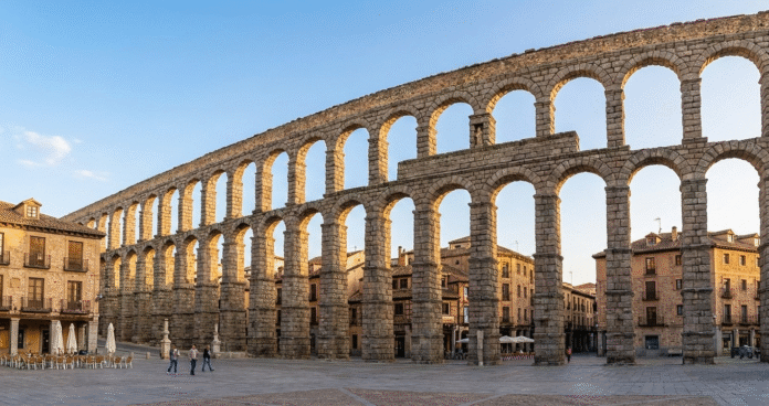 Segovia's Roman Aqueduct - Easy day trip from Madrid Roman aqueduct in Segovia with old town buildings, popular day trip from Madrid Spain