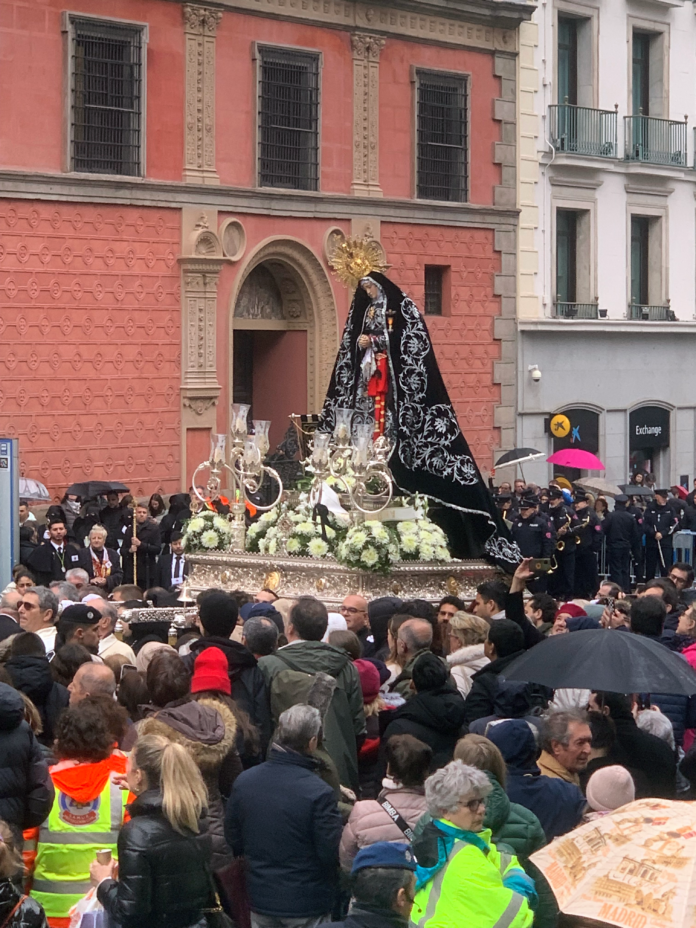 Semana Santa procession passing through historic Madrid street at sunset during Holy Week 2026
